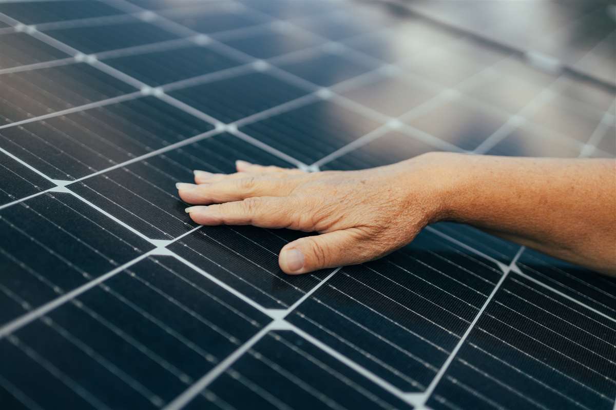 mano che sfiora tegole fotovoltaiche