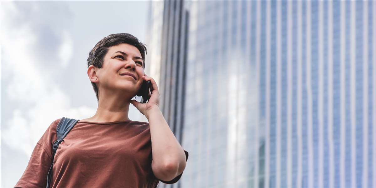 Donna parla al telefono in ambiente cittadino