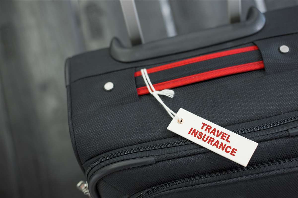trolley con cartoncino con su scritto assicurazione viaggio